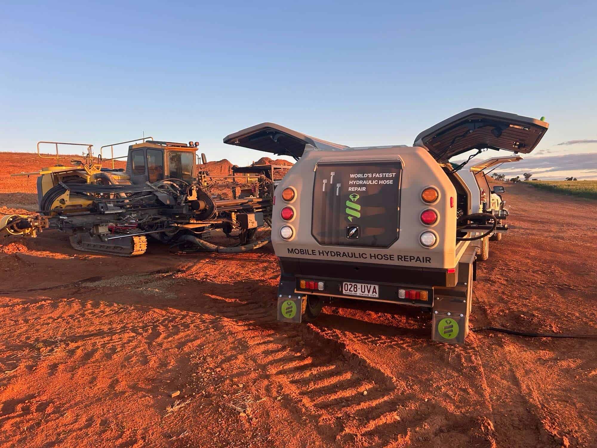Extensive hydraulic hose repair system on a mobile service truck in an open field.